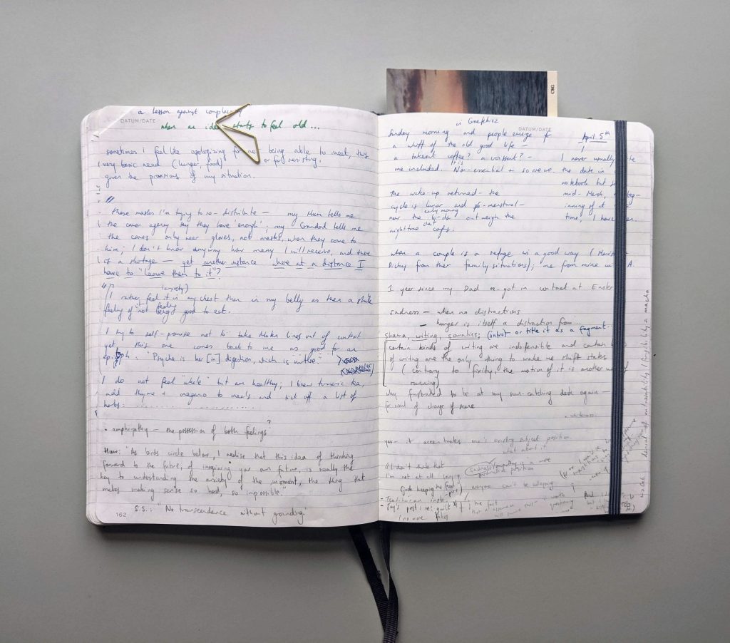 double spread of a notebook showing handwriting and bookmark 